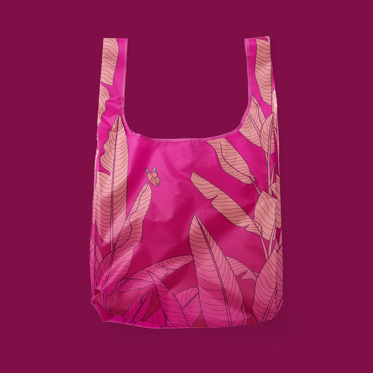 Pink reusable bag, detailing a banana leaf print with a butterfly.