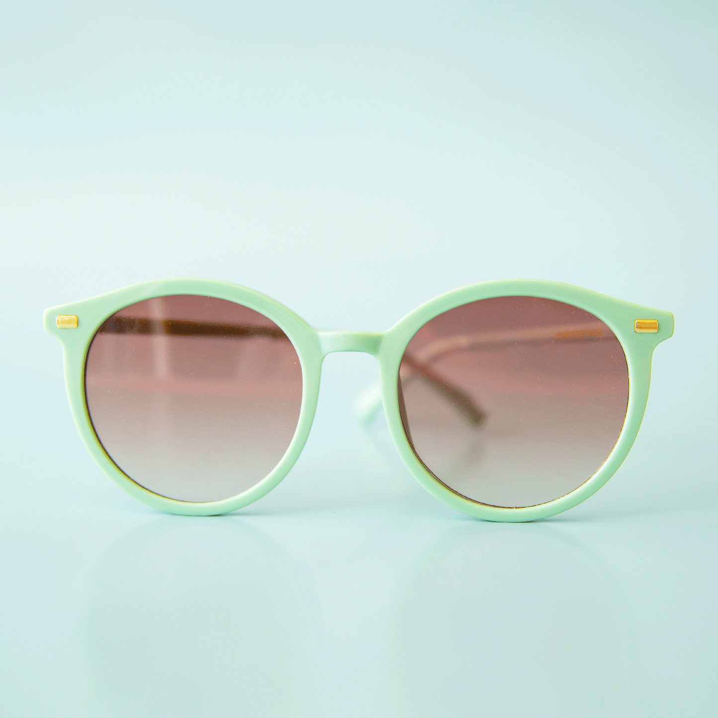 A pair of greenish blue round sunglasses.