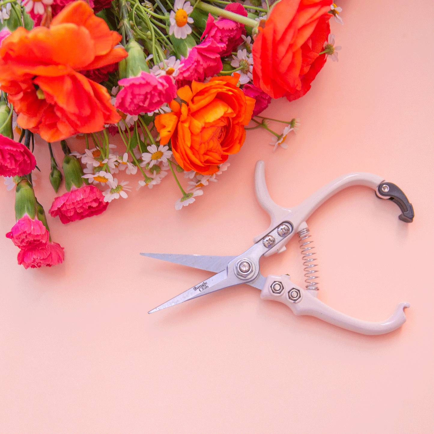 A pair of pruning shears with a cream colored handle.