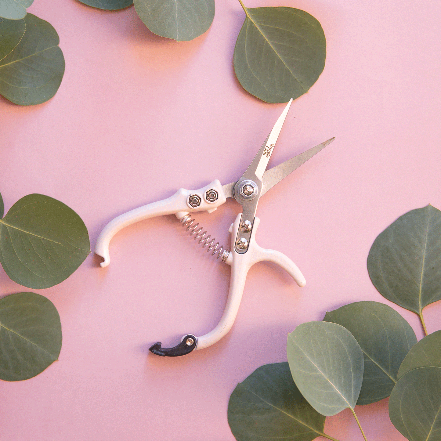 A pair of pruning shears with a cream colored handle.