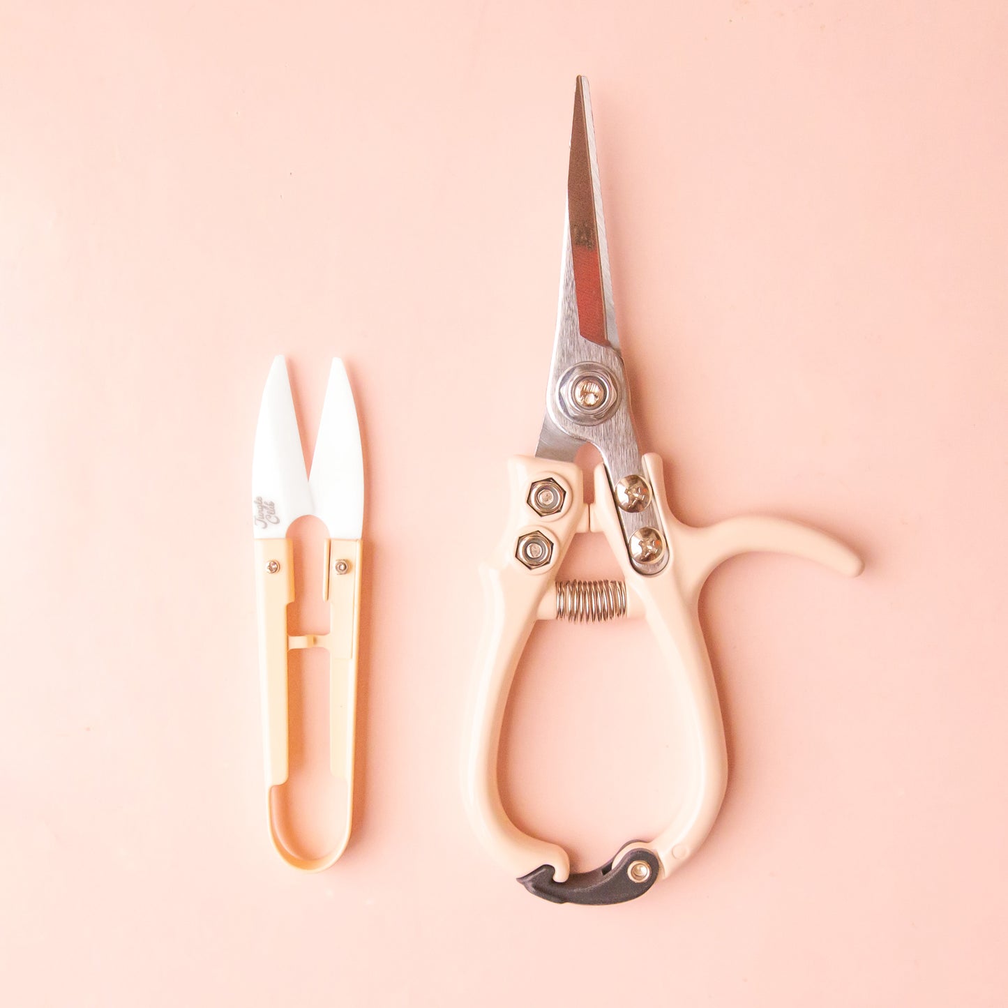 A pale pink pair of pruning shears and mini plant snips.