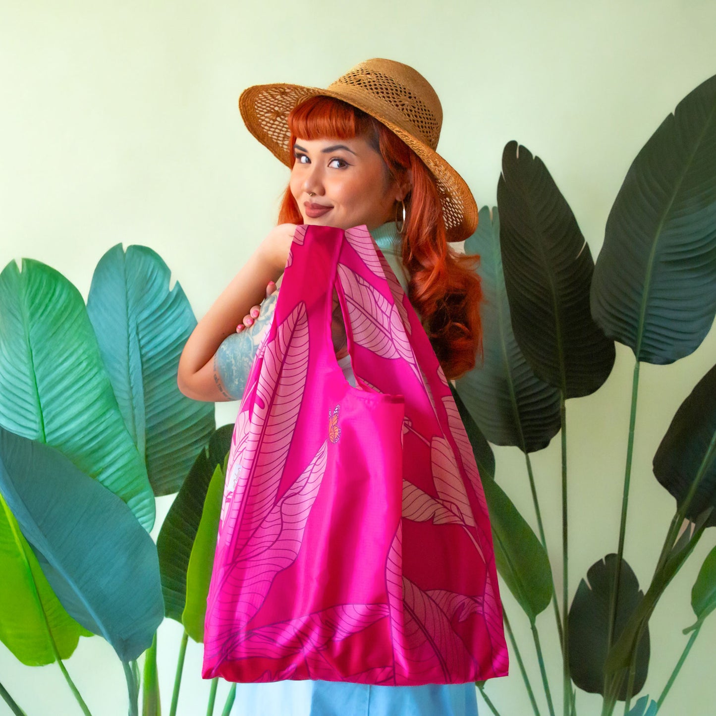 Pink reusable bag, detailing a banana leaf print with a butterfly.
