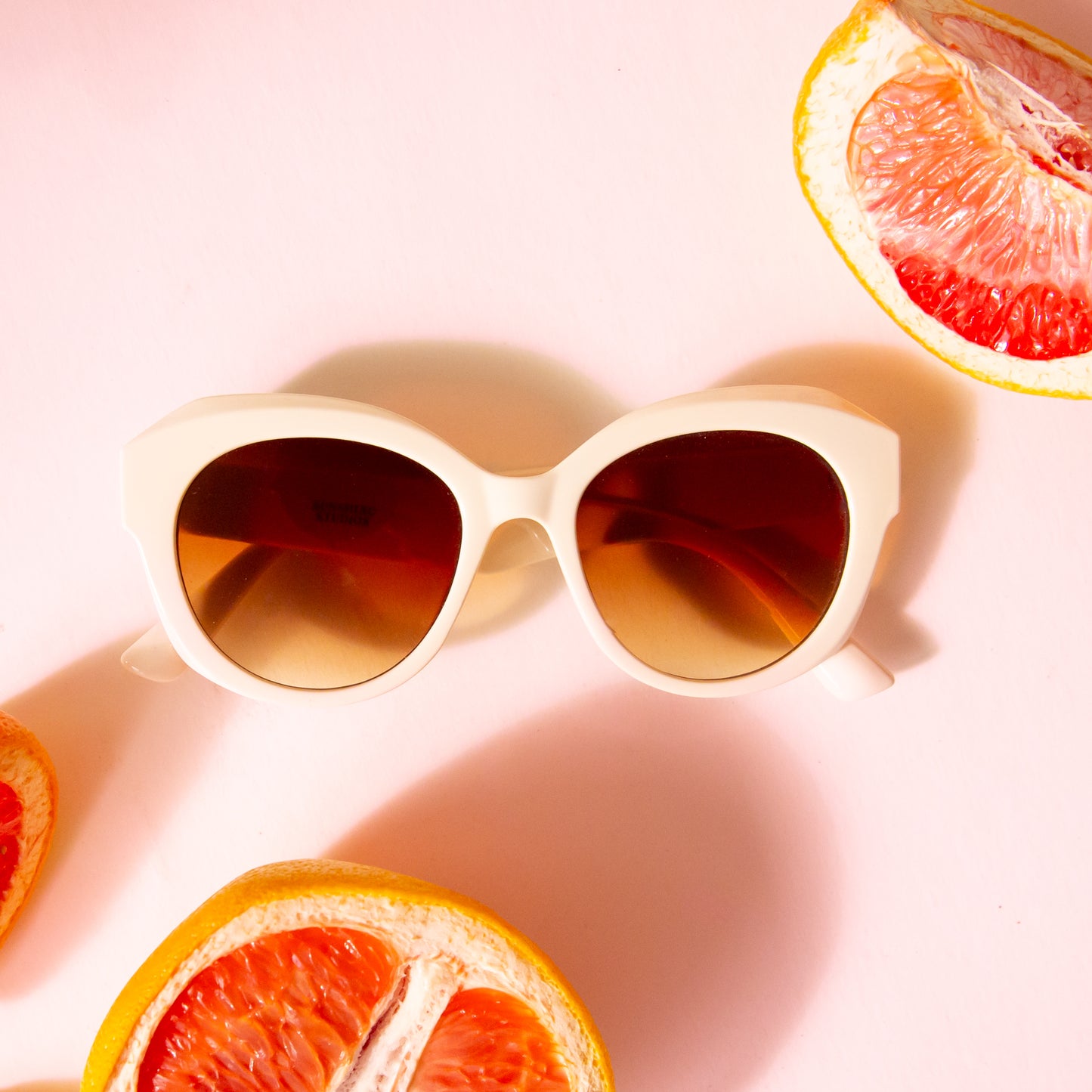 A white and brown lens pair of rounded sunglasses.