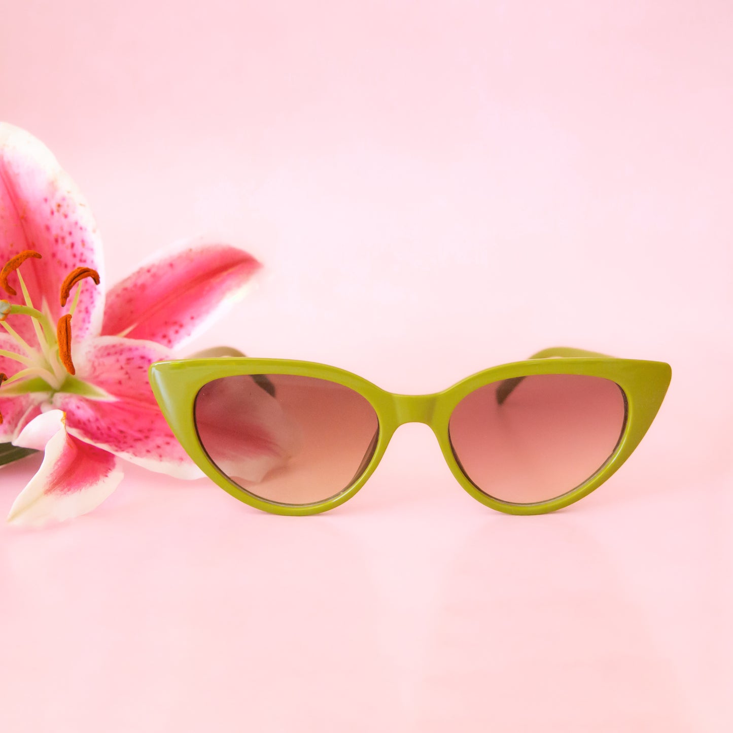 A pair of green cat eye shaped sunglasses.