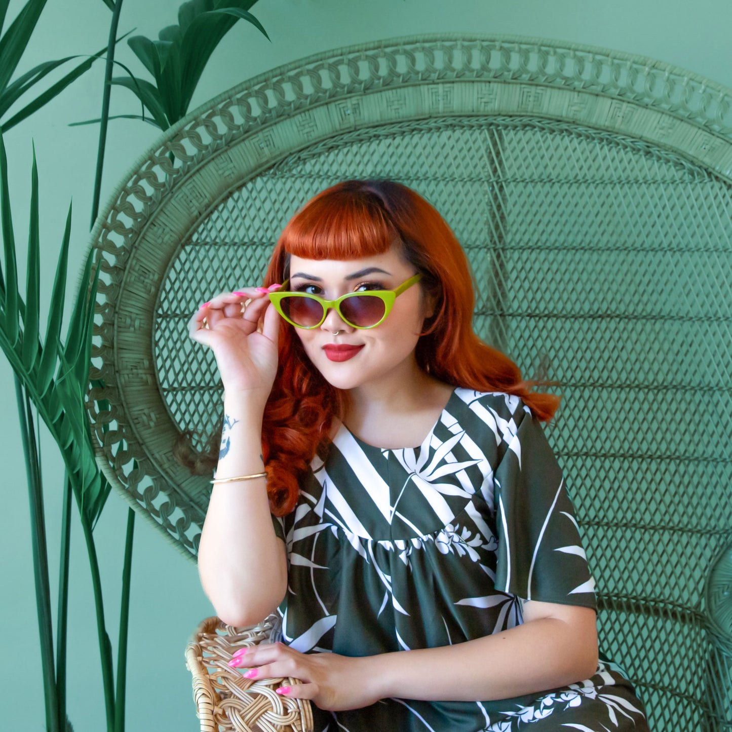 A pair of green cat eye shaped sunglasses.