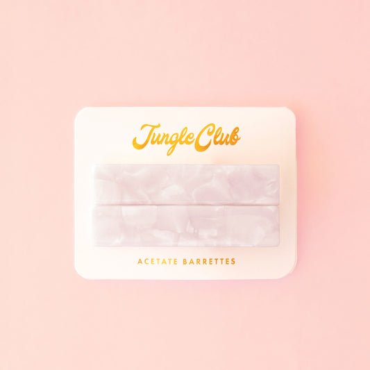 Marbled white acetate barrettes on a pink ground card that reads, "Jungle Club".