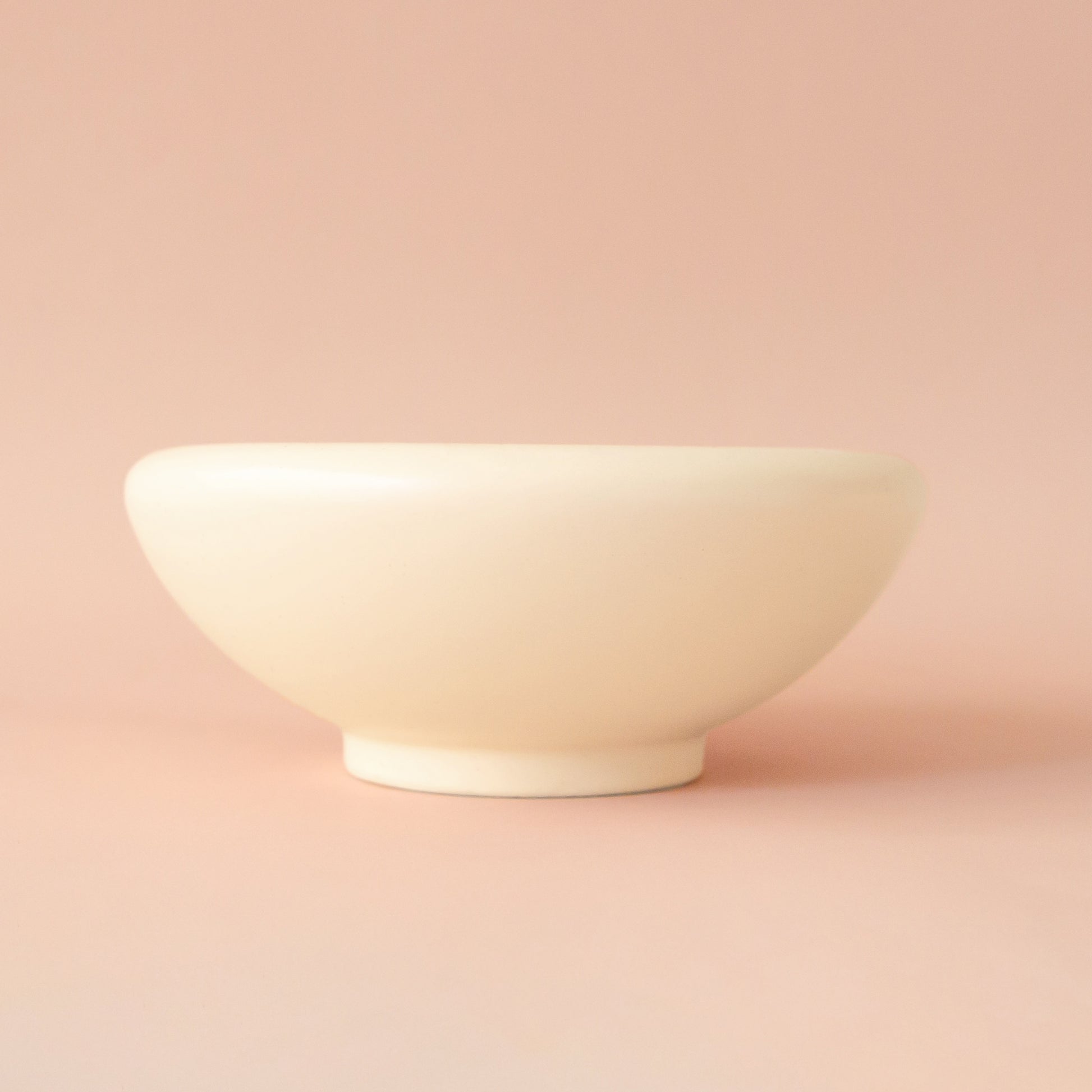 A rounded low pedestal bow in a vintage ivory shade. Plantings are just used for staging purposes and are sold separately. 
