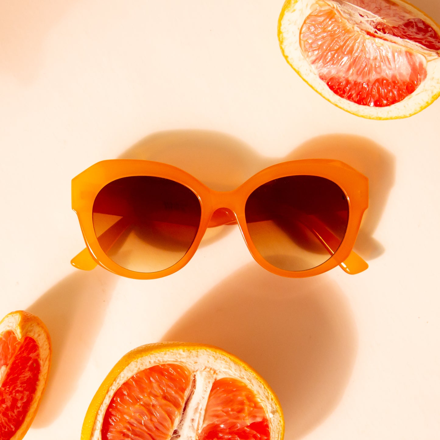 Chunky round orange sunglasses with a brown lens.