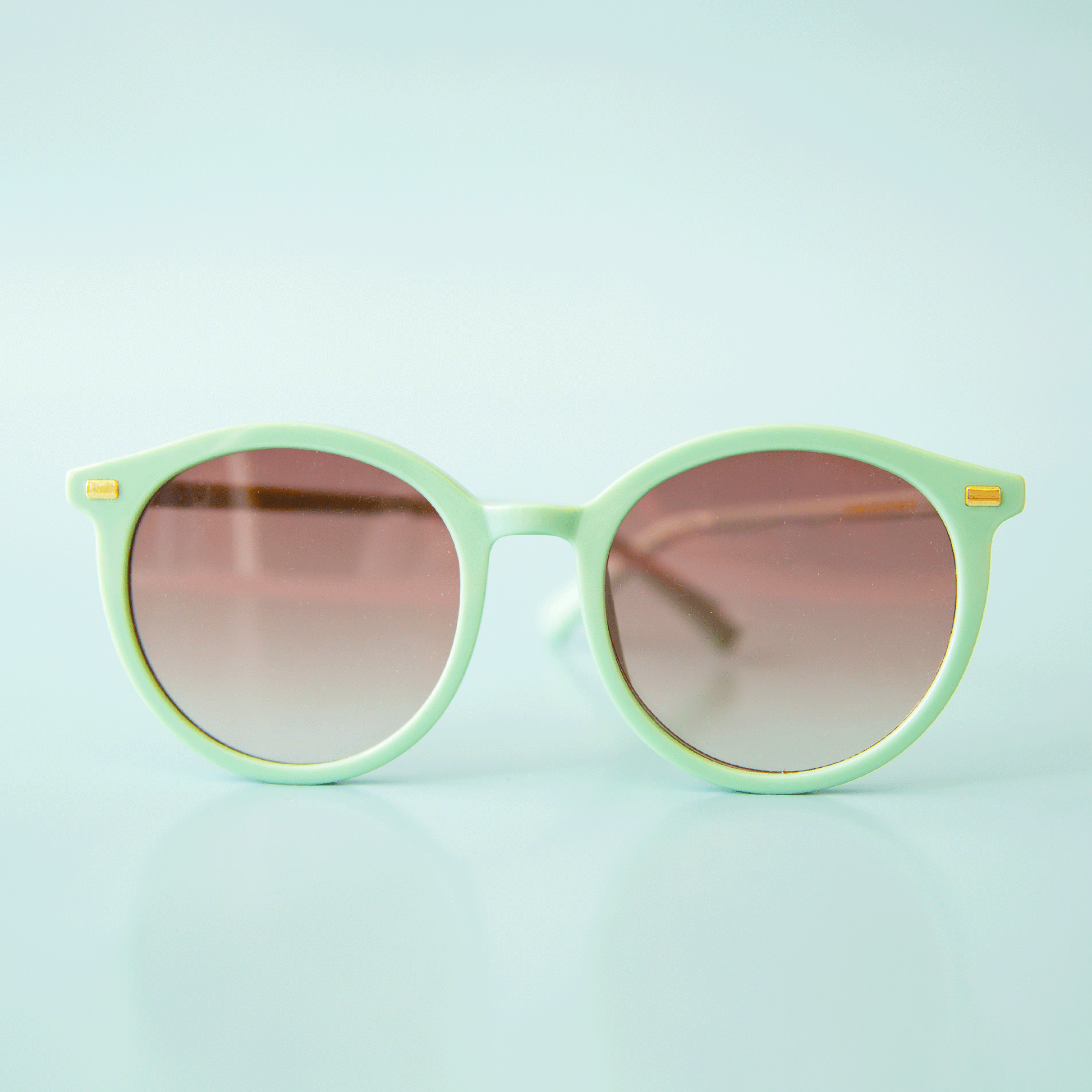 A pair of greenish blue round sunglasses. 