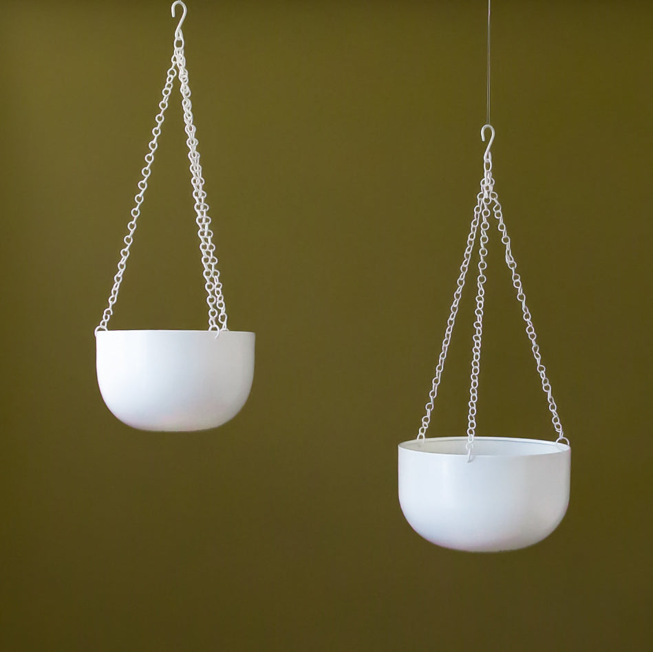 Two round white hanging planters with a metal chain hanger are shown against an olive green backdrop in two different sizes.