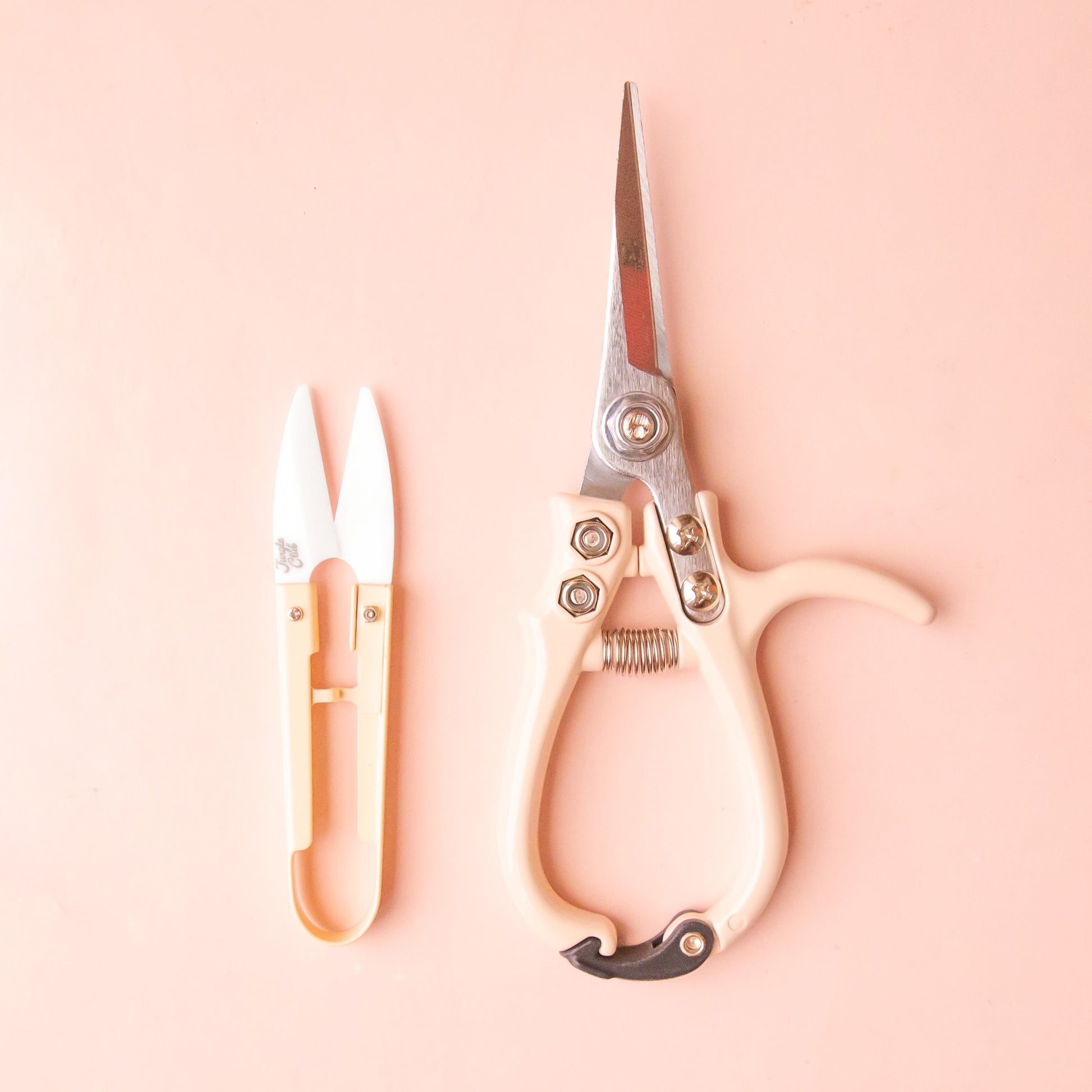 A pale pink pair of pruning shears and mini plant snips. 