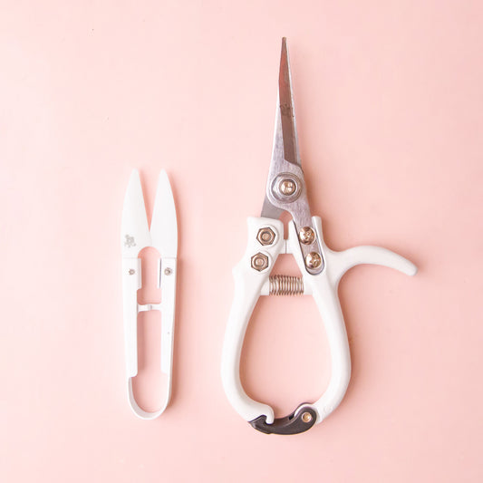 A pair of white pruning shears and mini plant snips. 