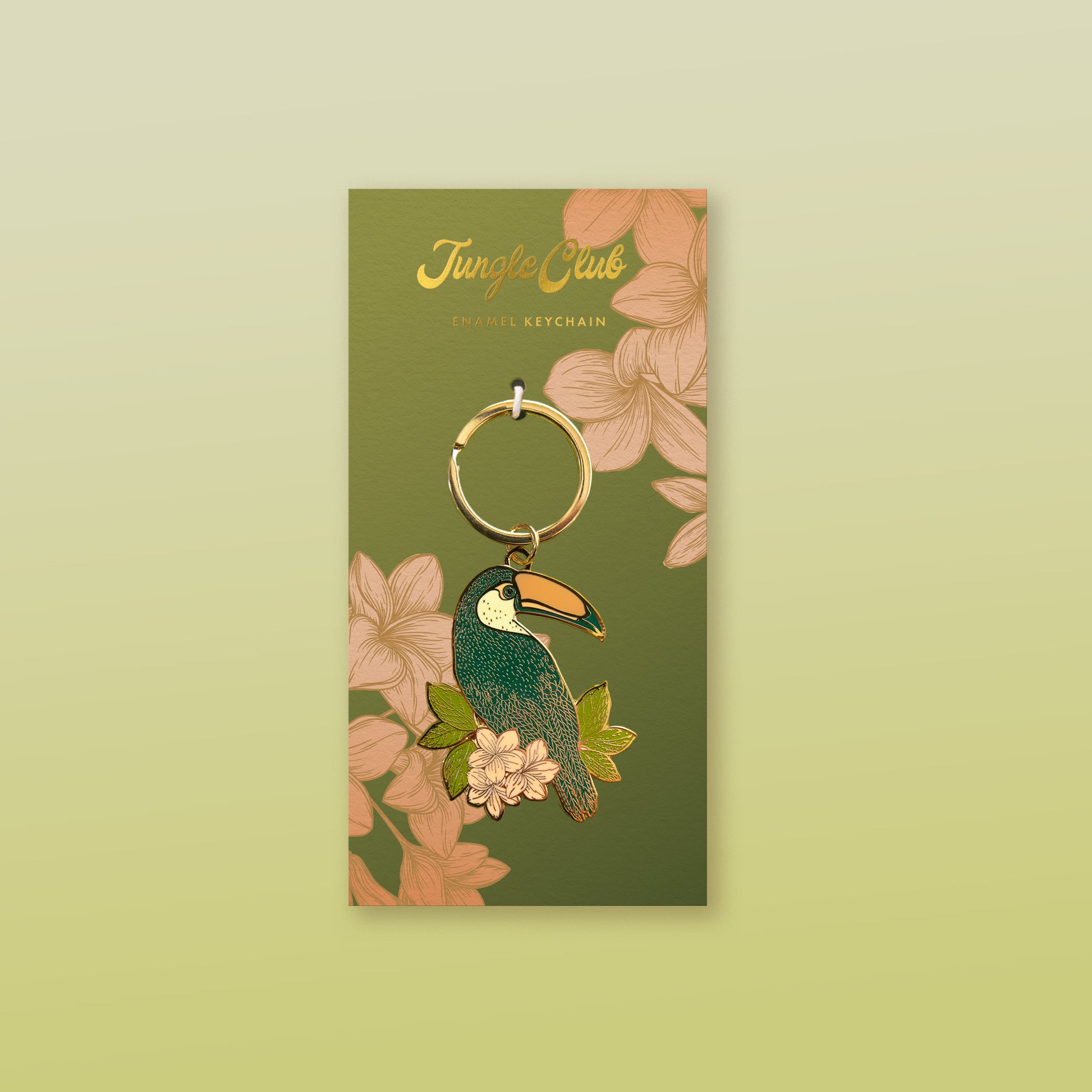 A toucan shaped enamel keychain on a floral print packaging backer.