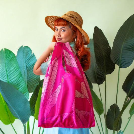 Pink reusable bag, detailing a banana leaf print with a butterfly. 
