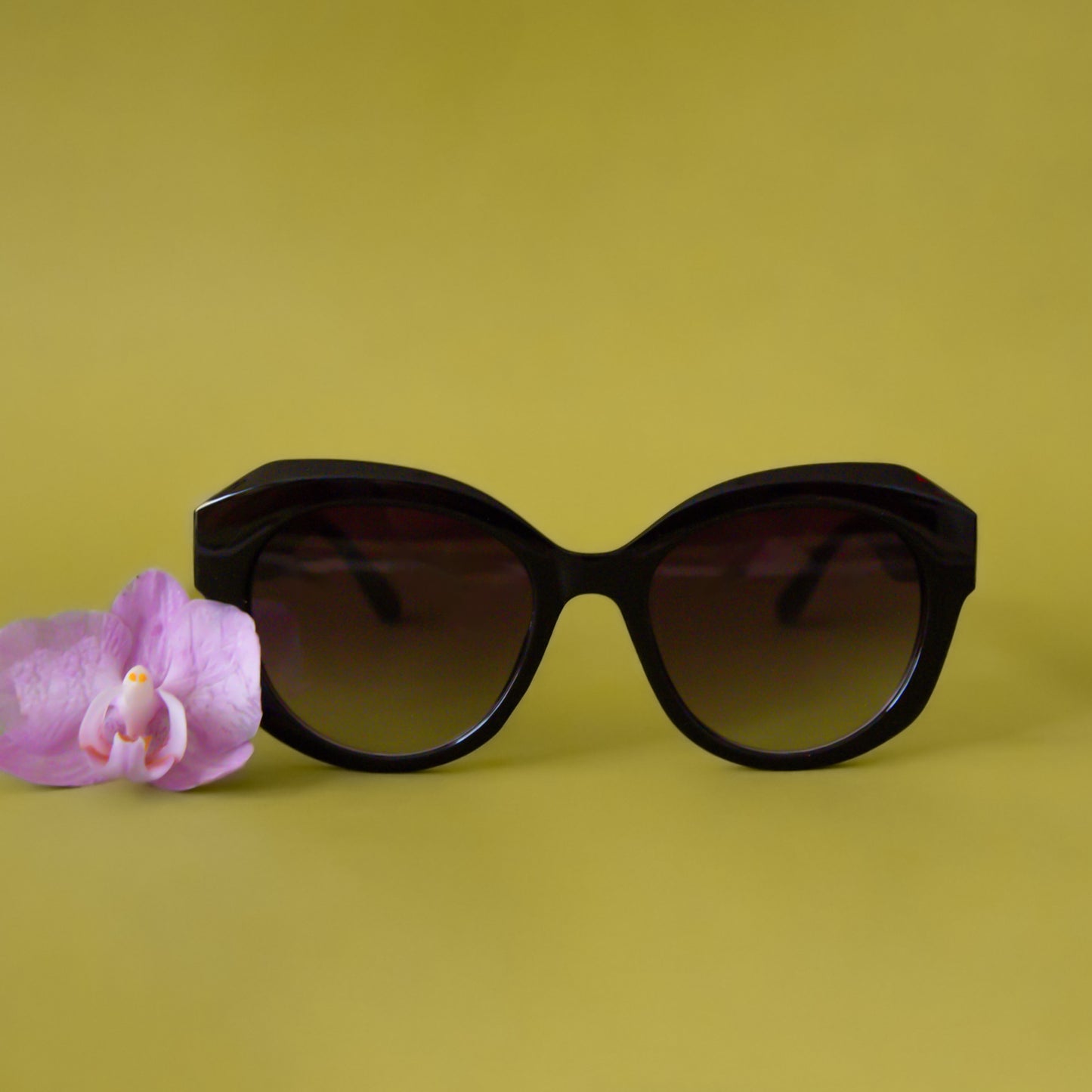 A pair of black round, oversized sunglasses.