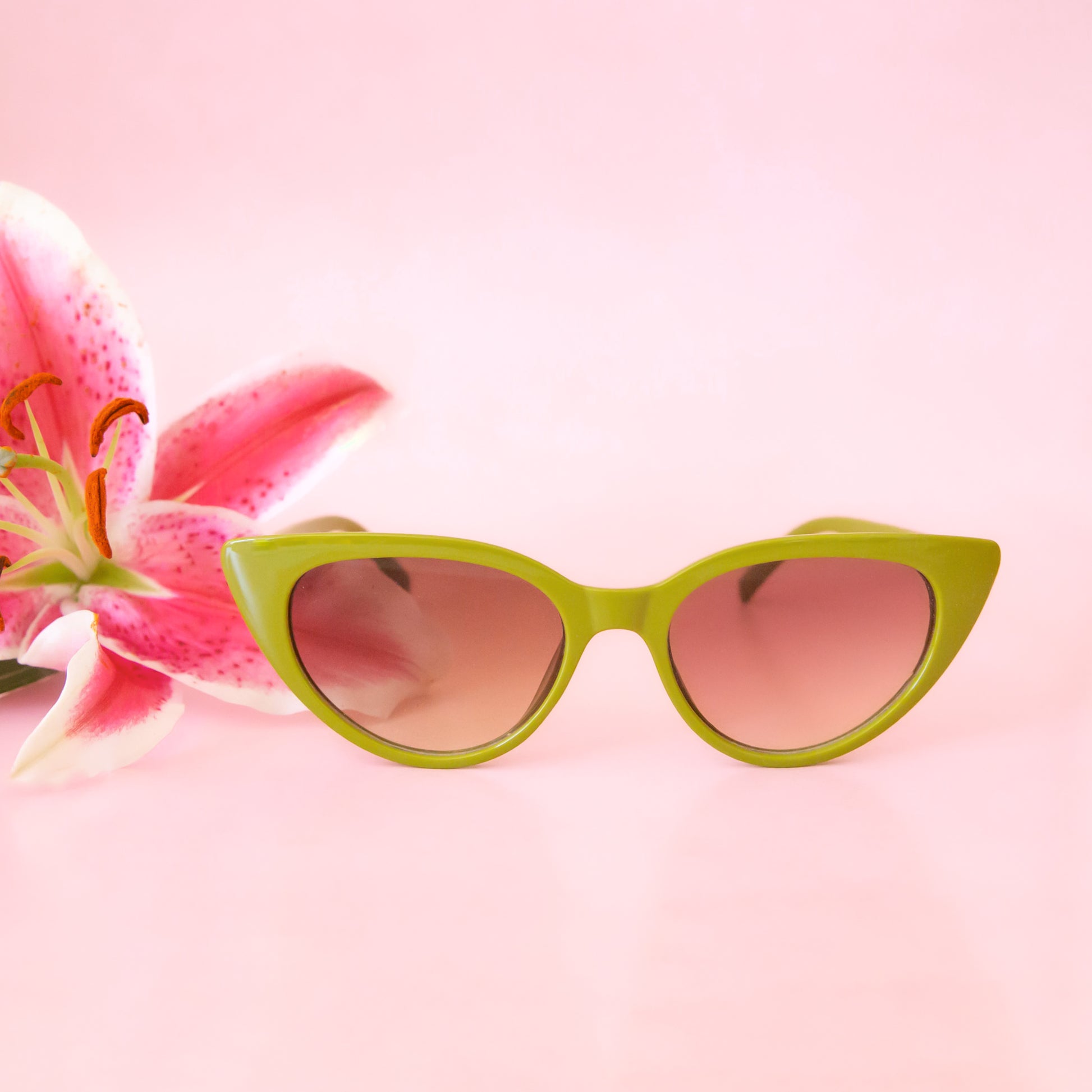 A pair of green cat eye shaped sunglasses. 