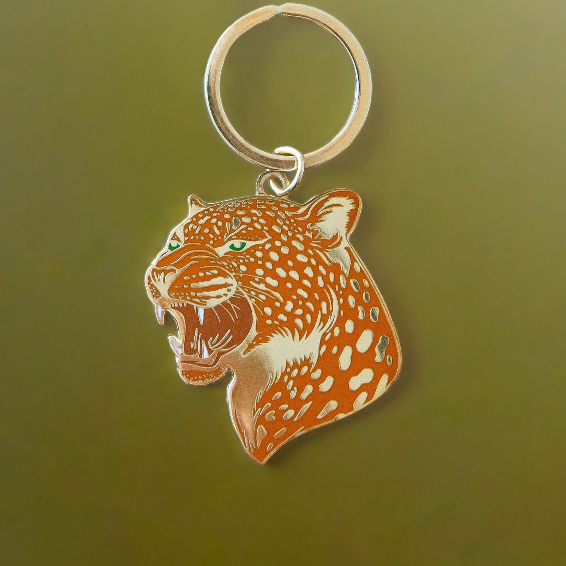 An orange leopard keychain with gold details. 