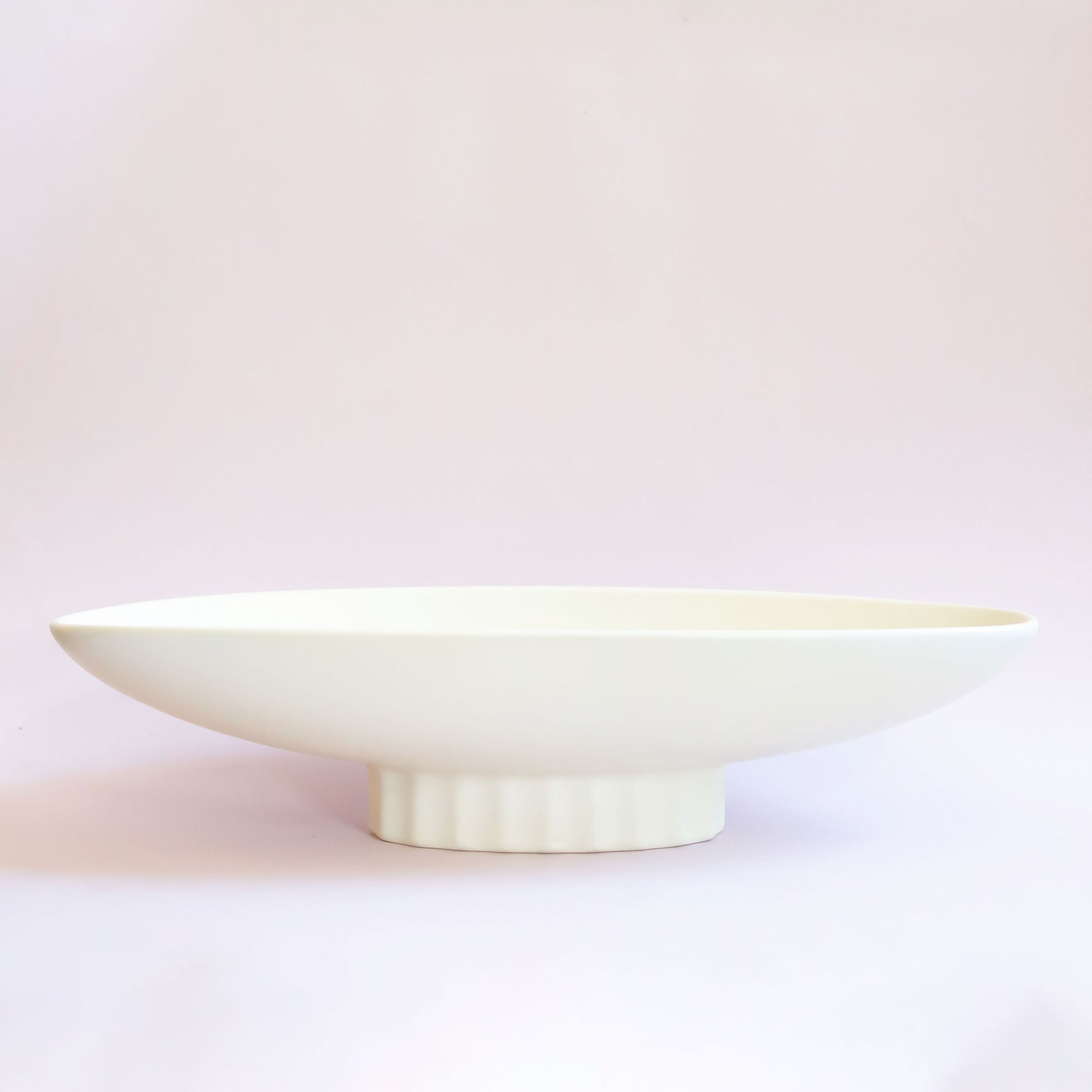 An elongated ceramic pedestal bowl. 