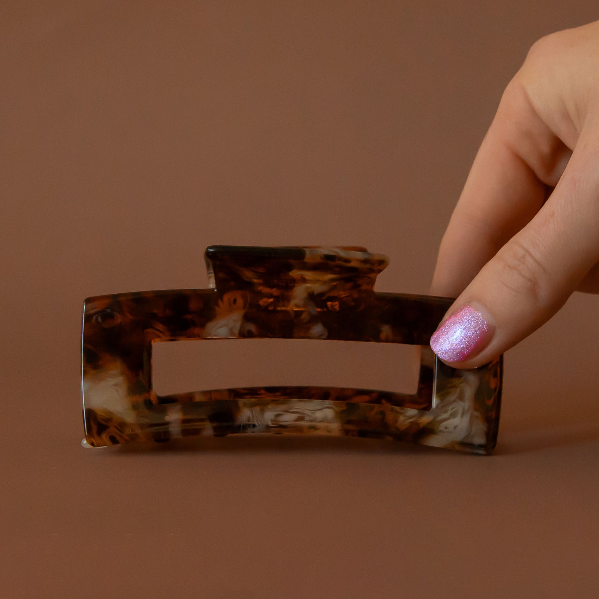 A brown feline animal print inspired design on a plastic hair clip.