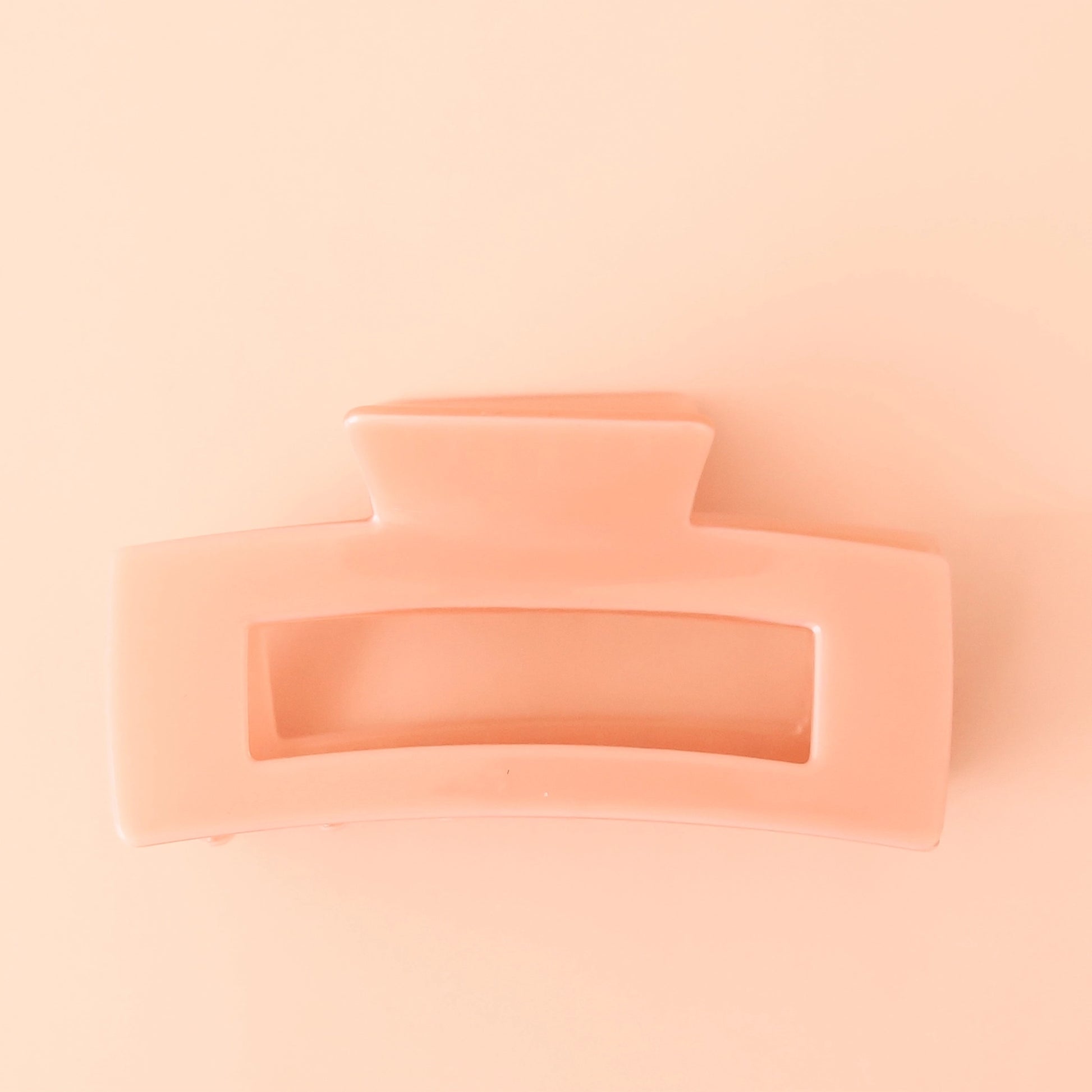 On a light pink background is a light pink rectangle hair clip.
