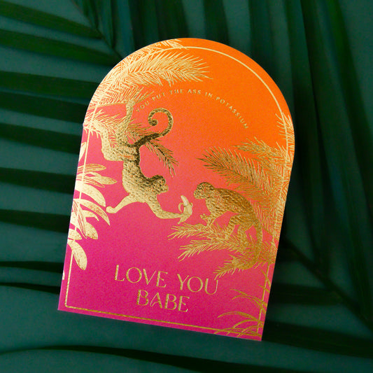 pink and orange ombre arched shape card with gold foiled monkey illustrations and gold text that reads, "You Put The Ass In Potassium Love You Babe".