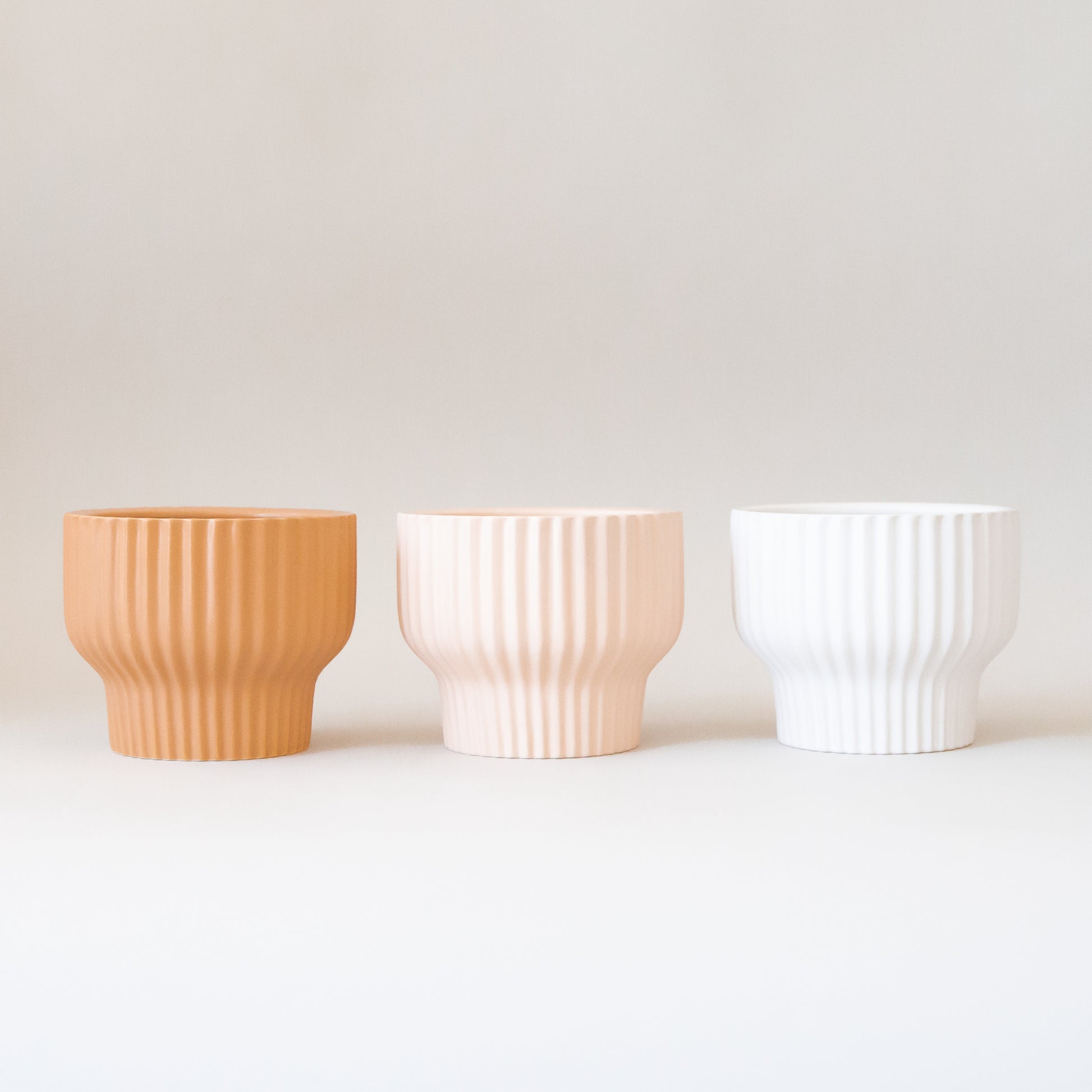 The latte presley bowls next to two other color ways in light pink shade and white. 