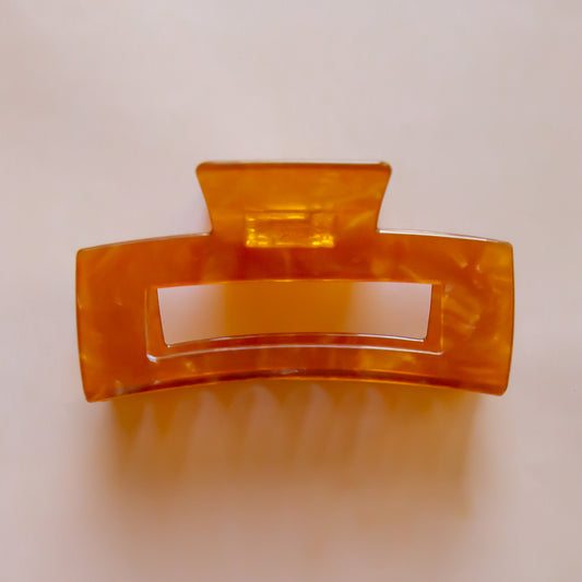 A light brownish orange rectangle hair claw clip. 