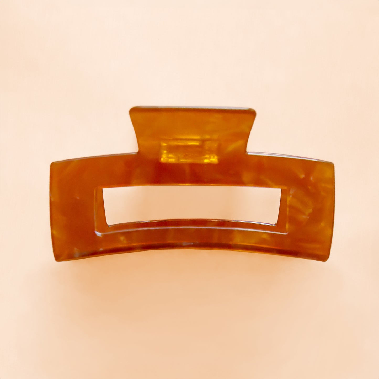 A light brownish orange rectangle hair claw clip. 