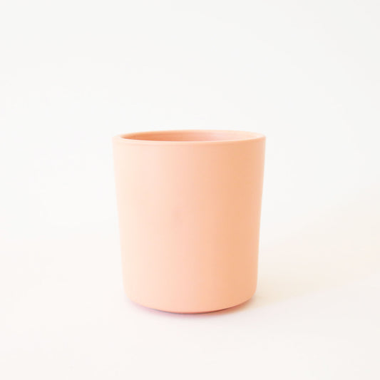 A vibrant salmon colored ceramic vase perfect for a succulent or a small plant.