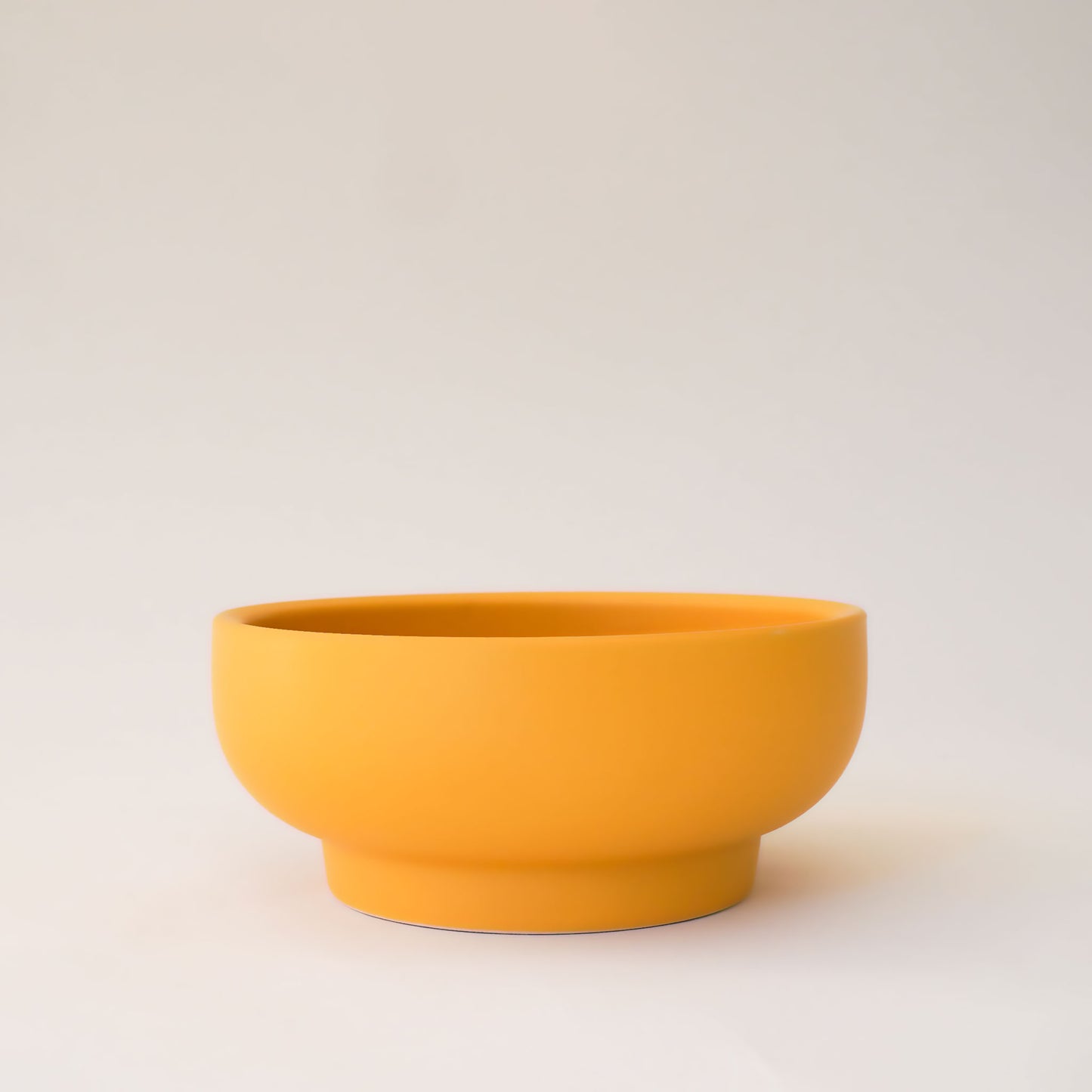 Bright orange bowl planter that tapers towards the base.